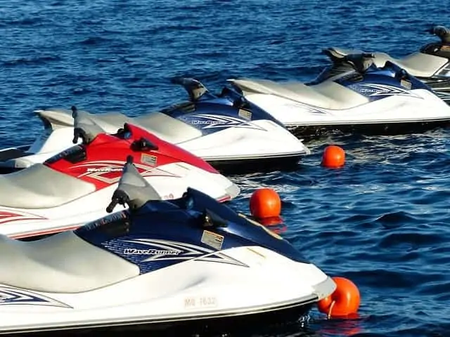 Several jet skis floating tethered to anchor floats